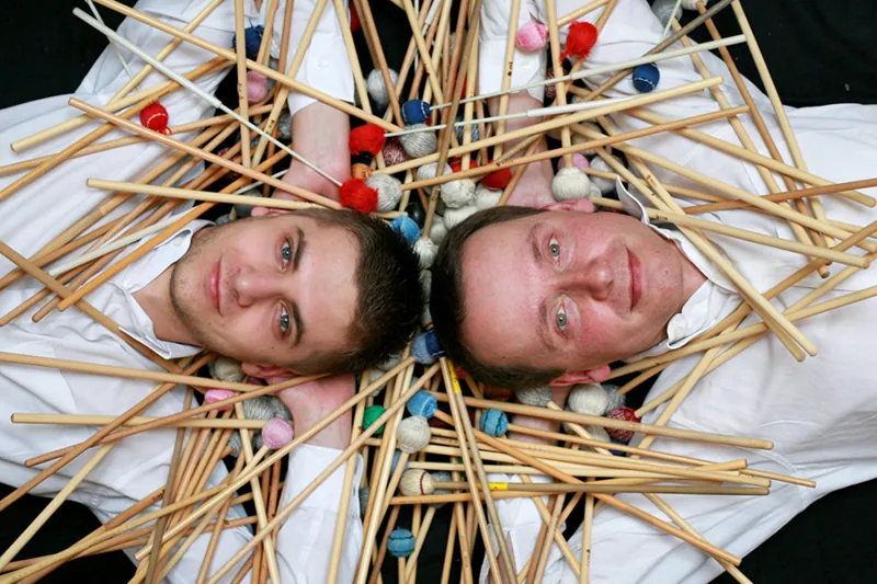 Both players lying among scattered sticks and mallets